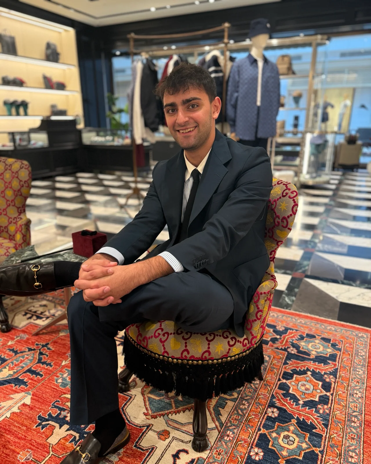 Jordan Khoury, founder of GUARD by Khoury, seated in a Gucci boutique